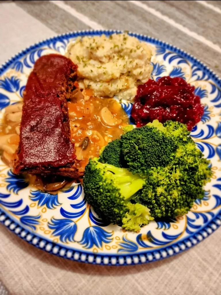 Lentil loaf with mushroom gravy, mashed potatoes, cranberry sauce, and broccoli

