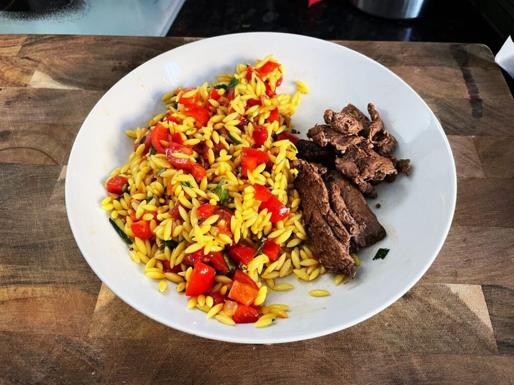 Orzo and sun dried tomato salad with chargrill steaks