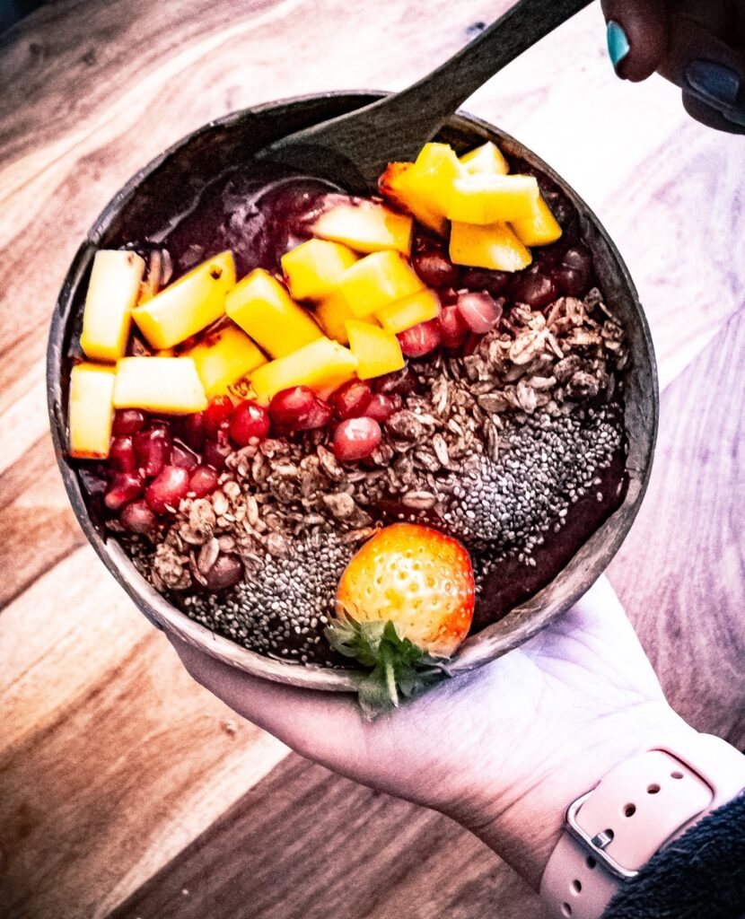Açai and blueberry Smoothie bowl with pomegranate, homemade cacao granola, chia seeds and pineapple chunk - Cquinnvegan